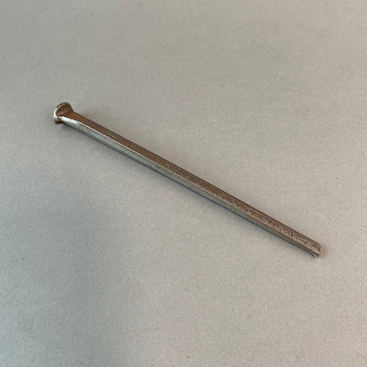 Photo of hand forged nail on grey background