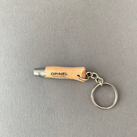 Small key chain pocket knife made out of beech wood with stainless steel blade connected to key ring with small chain-closed