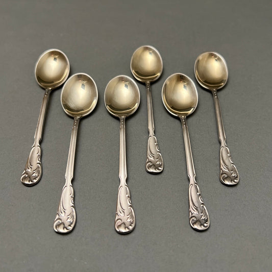 Set of six spoons laying on gray background