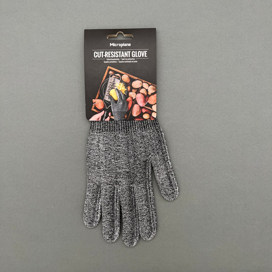 A pair of gray cut resistant gloves from Microplane laying on a gray background
