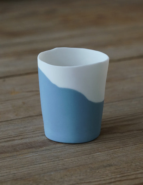 A small blue and white colored porcelain cup