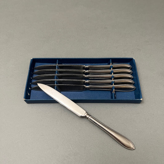Set of six fruit knives in blue box laying on gray background
