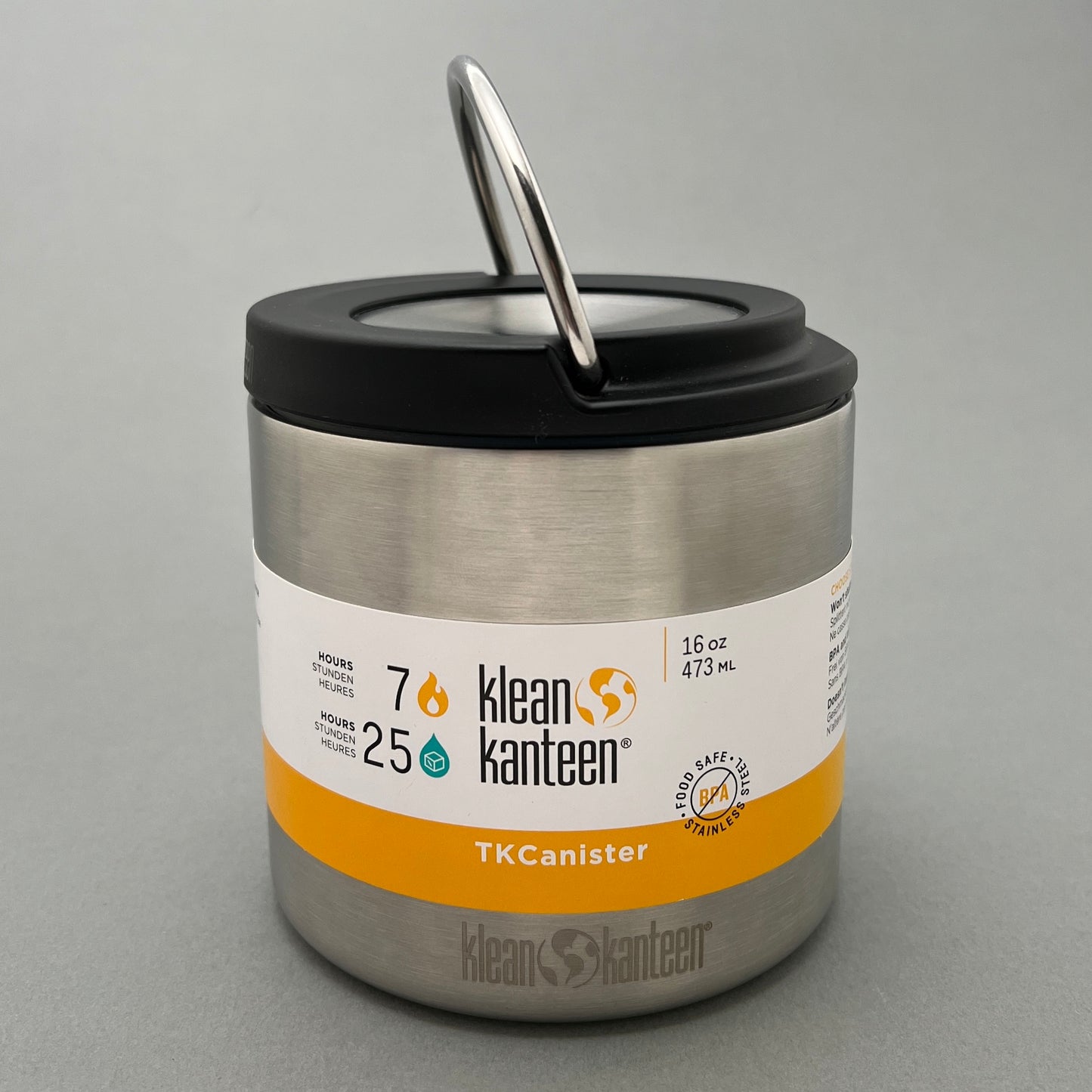 A 473ml stainless steel food canister with a insulated screw on top from klean kanteen standing in a gray background