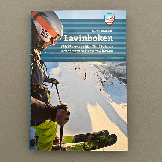 A blue colored book called "Lavinboken" with a picture of a guy mountain skiing on the cover