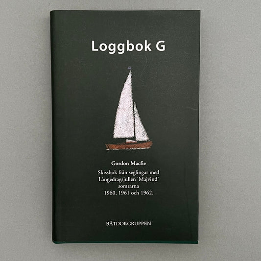 A green colored book called "Loggbok G" written by Gordon Macfie with a drawing of a sailing boat on the cover¨