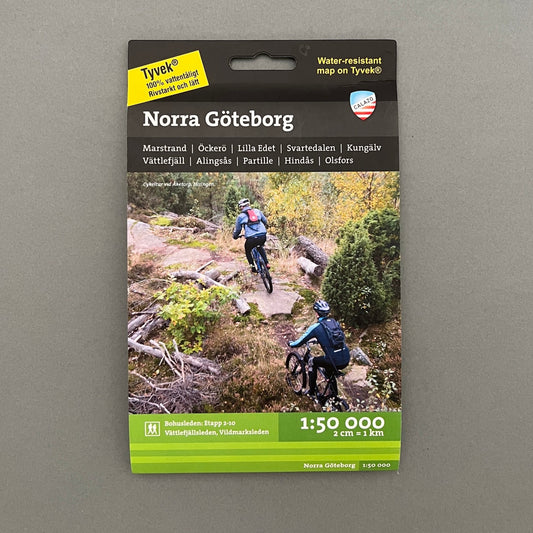 A black and green book called "Norra Göteborg" with a picture of two people riding mountain bike on the cover